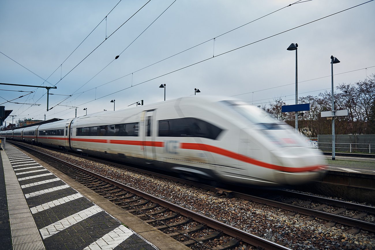 Weißer ICE, der an einem Bahnhof ankommt